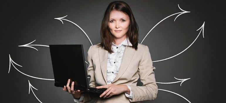Žena koja drži laptop.